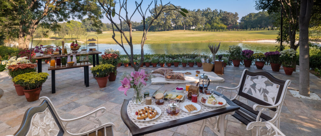 Elegant outdoor breakfast setup by the lake at Karma Chalets for pet-friendly staycation near Delhi