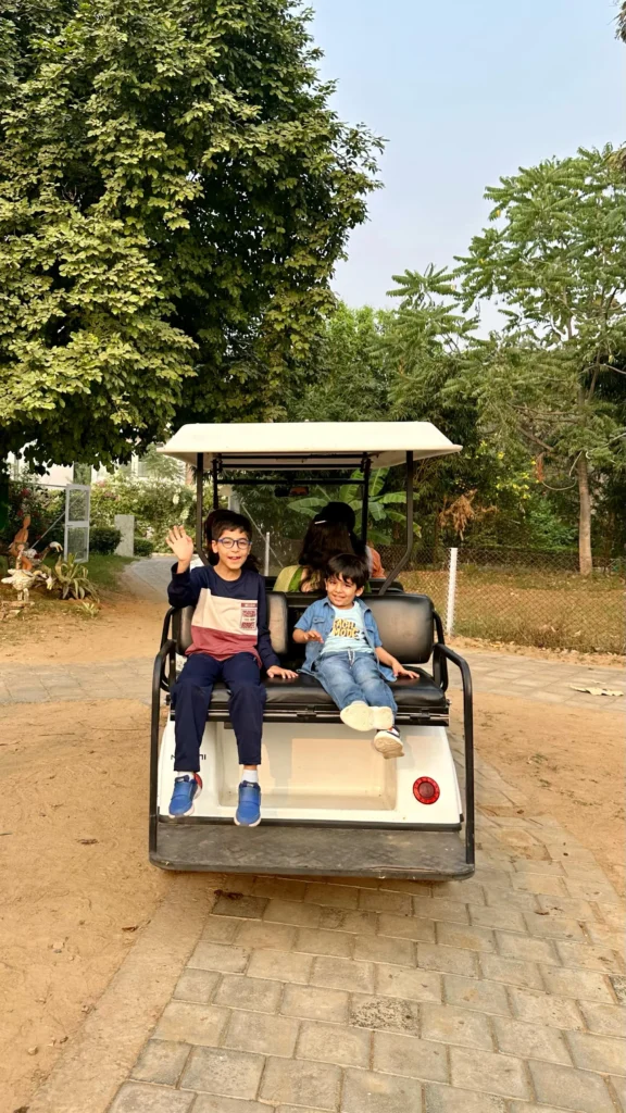 Kids having fun outdoors on a golf cart ride at Karma Chalets retreat