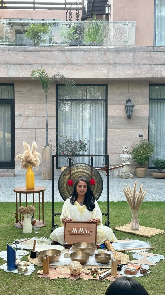 A sound healing session in karma chalets surrounded by singing bowls, a gong, and natural decor.